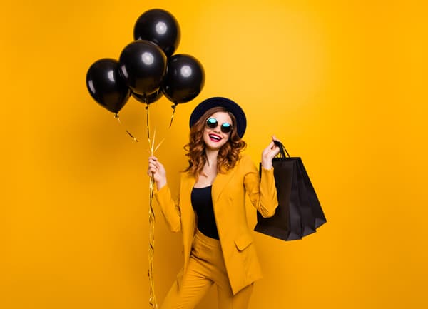 Frau mit Ballons und Einkaufstaschen