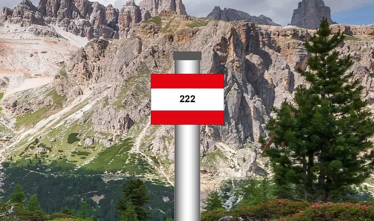 rot-weiß-rot gestreiftes Schild mit Bergen im Hintergrund